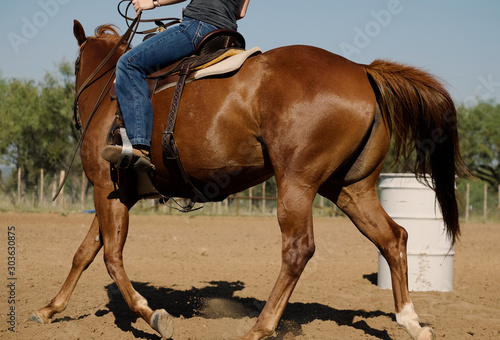 Western horseback riding shows rider and horse close up practicing barrel racing rodeo sport.
