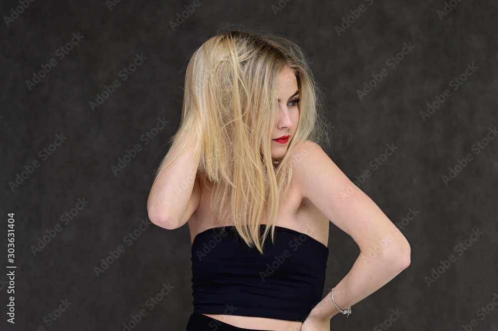 The concept of fashionable glamor, cosmetics and beauty with a pretty girl. Portrait of a fashionable beautiful blonde model with long hair, great makeup, on a gray background. The concept of fashionable glamor, cosmetics and beauty with a pretty girl. Portrait of a fashionable beautiful blonde model with long hair, great makeup, on a gray background.
