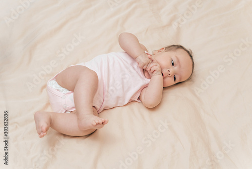 A five-month-old baby. Charming girl in a cozy bedroom. Newborn baby resting in bed. Nursery for children. portrait of little baby