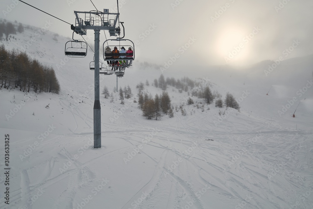 Ski lift on the Alps snowing in gloomy weather Ski lift on the Alps snowing in gloomy weather