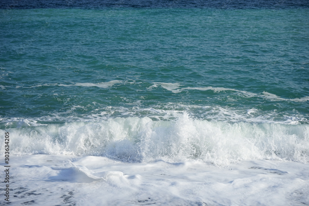 Splashing waves in a storm at sea with blue sky Splashing waves in a storm at sea with blue sky