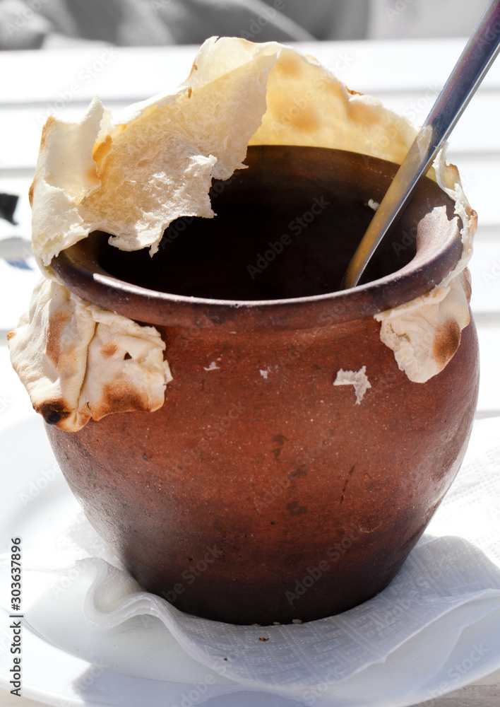 Fotografie Clay pot covered with bread at outdoor cafe