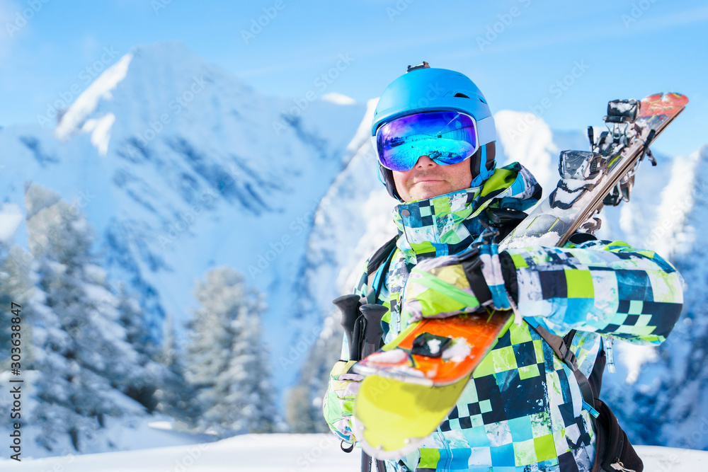 Φωτογραφία Portrait of sports man in helmet and mountain skis against background of mountai