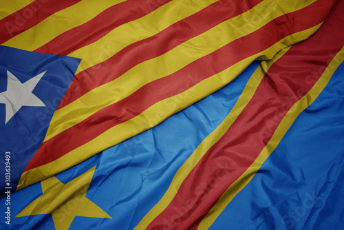 waving colorful flag of democratic republic of the congo and national flag of catalonia.