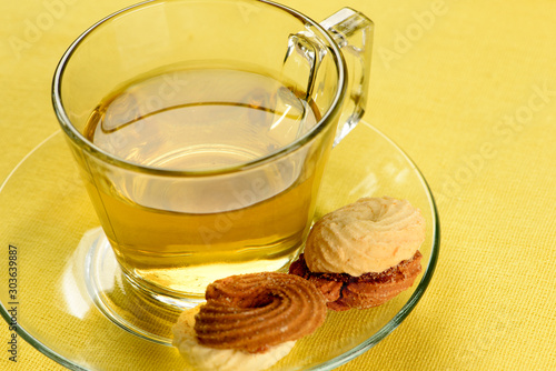 cup of fennel tea with cookies on yellow towel