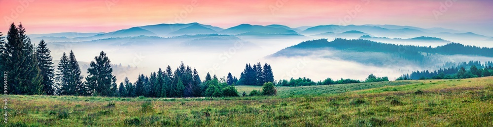 Panorama morning view of foggy Carpathian mountains. Great summer sunrise in Borzhava ridge, Transcarpathian, Ukraine, Europe. Beauty of nature concept background..