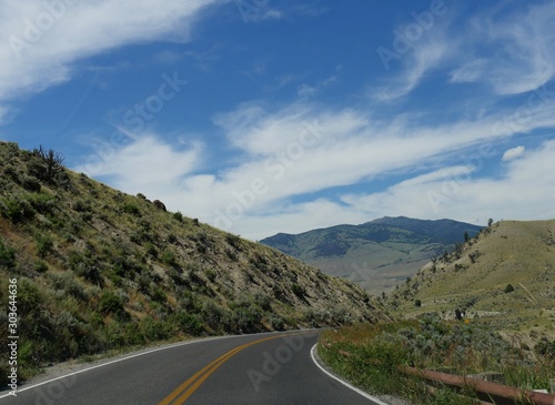 Scenic winding road at Yellowstone National Park on a beautiful day near the Gardiner exit in Montana. © raksyBH
