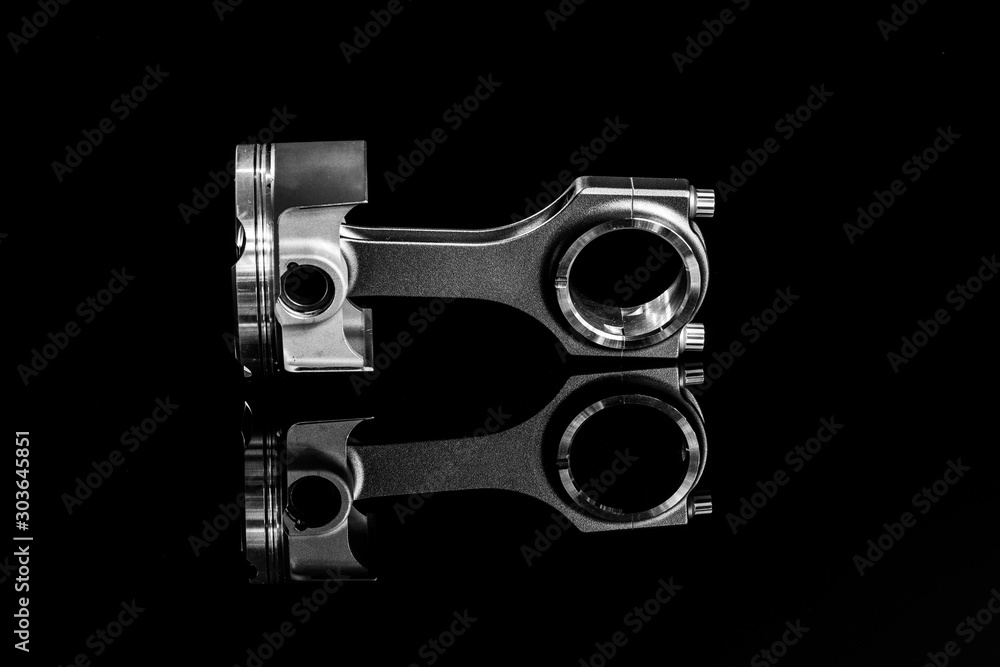 hight performance racing motorcycle pistons and connecting rods on a black reflective background hight performance racing motorcycle pistons and connecting rods on a black reflective background