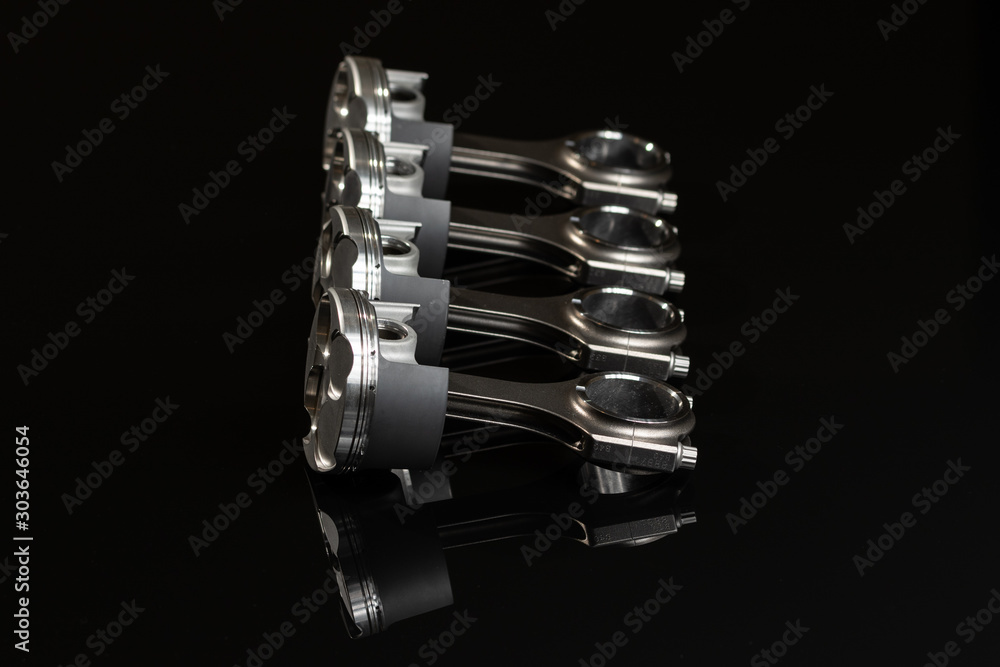 4 motorcycle pistons and connecting rods on black mirror, high performance racing. 4 motorcycle pistons and connecting rods on black mirror, high performance racing.