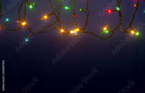 Christmas lights on blue background with copy space. © Achira22