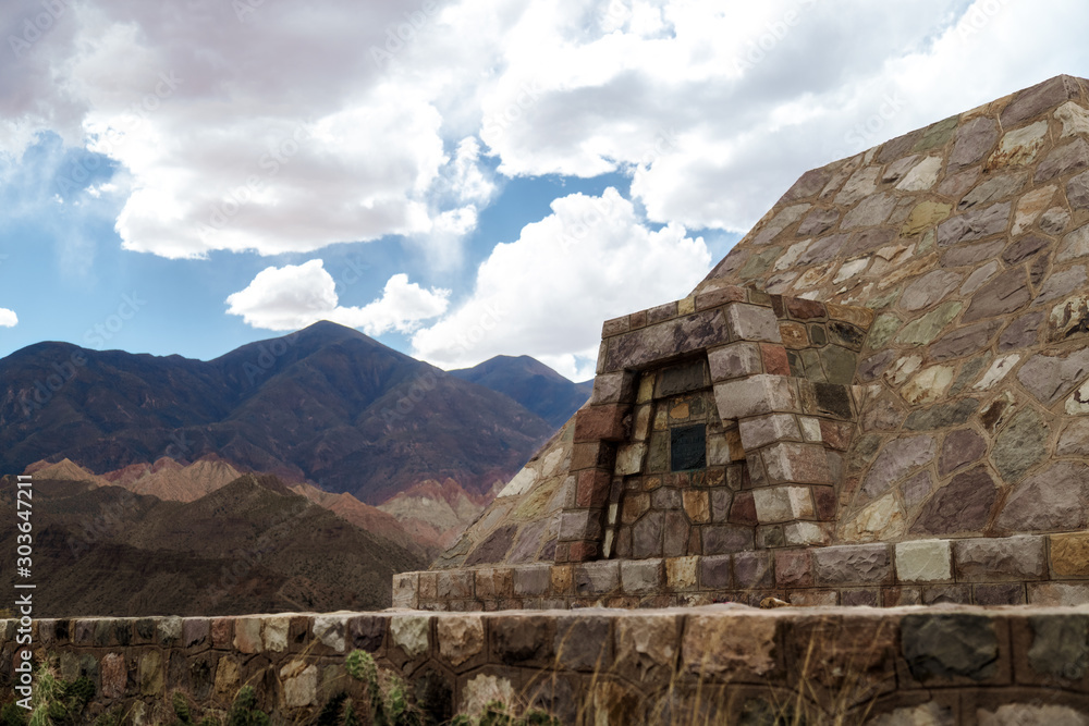 Stone pyramid at the archaeological site Pucara de Tilcara with mountains in the background in Jujuy, Argentina