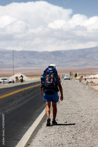 Young backpacker hitchhiking on the Salinas Grandes road in Jujuy, Argentina