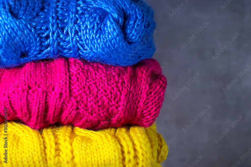 Fototapeta premium Knitted bright multi-colored things on a gray background. DIY things concept.