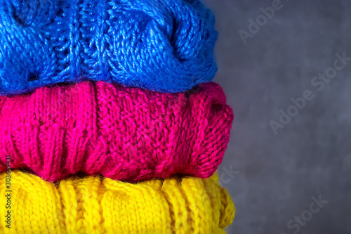 Knitted bright multi-colored things on a gray background. DIY things concept.