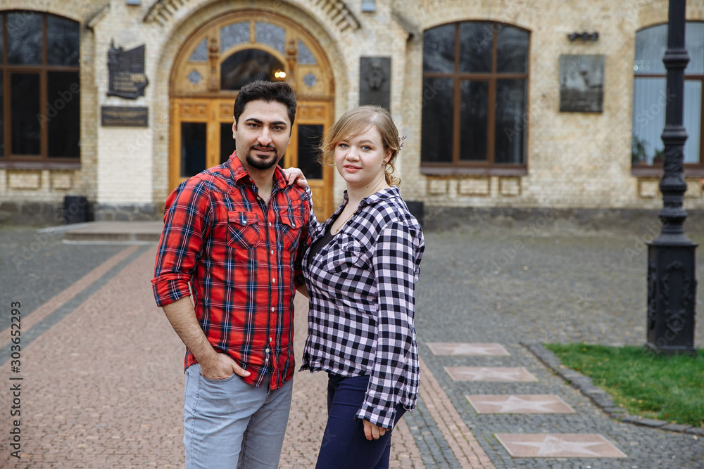couple of students in love holding hands posing on a university background