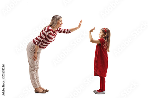 Young woman making a high-five gesture with a girl in a red dress