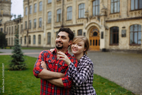 Loving couple in plaid shirts, against the background of the university