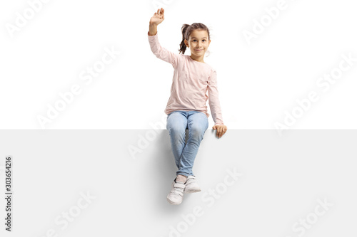 Little girl on a panel waving 