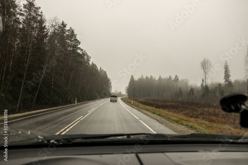 The view from the side window of the car. Rural landscape. Fields, hills, trees. Autumn, evening, cloudy. © Viktor