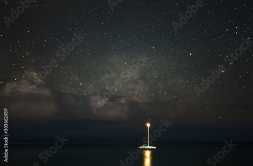 yacht in the sea on a background of stars and clouds © vadimborkin