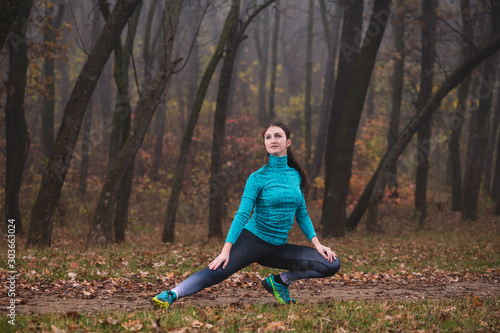 Woman sit in lateral lunge in park
