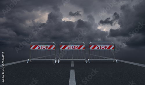 Obraz na plátně Asphalt road blocked by barriers with the words Stop and dark, gloomy clouds i