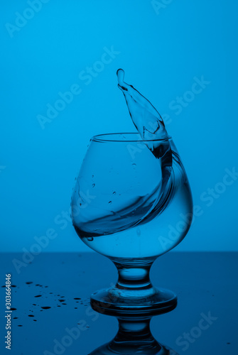 splash of water in a blue glass with drops on glass