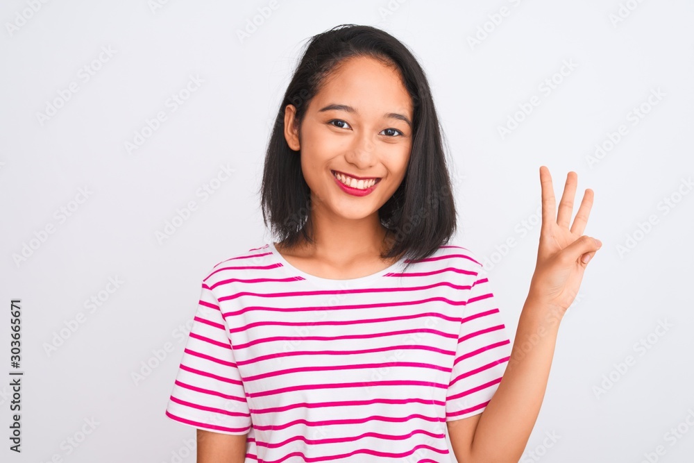 Young chinese woman wearing striped t-shirt standing over isolated white background showing and pointing up with fingers number three while smiling confident and happy. Young chinese woman wearing striped t-shirt standing over isolated white background showing and pointing up with fingers number three while smiling confident and happy.