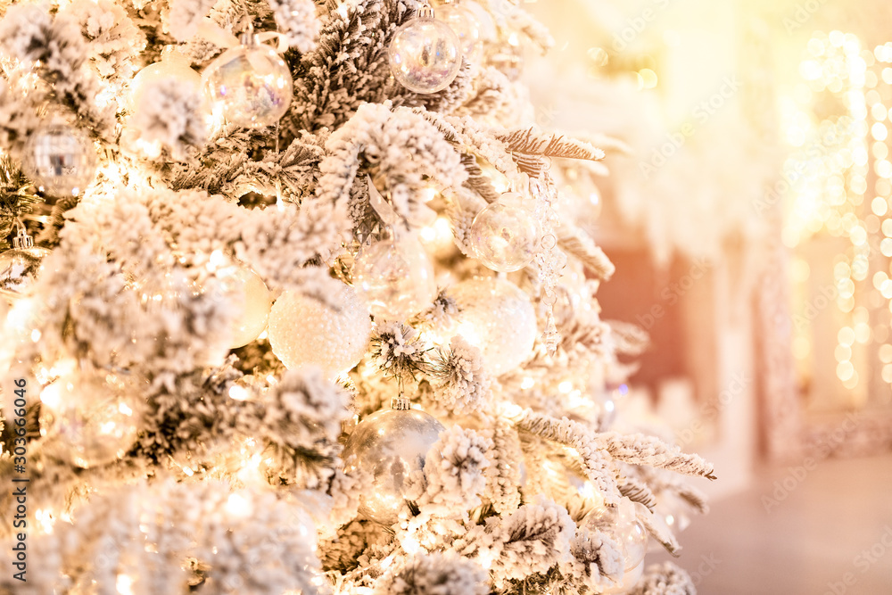 Christmas tree background with artificial snow decorated toys balls, snowflakes, branch golden illumination Christmas tree background with artificial snow decorated toys balls, snowflakes, branch golden illumination