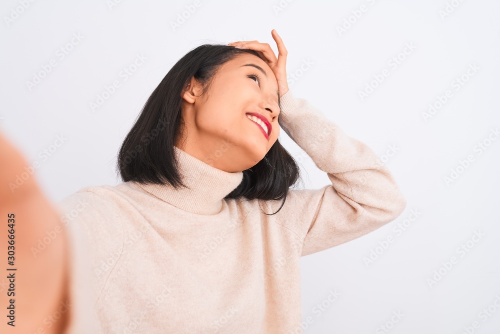 Young chinese woman wearing turtleneck sweater make selfie over isolated white background stressed with hand on head, shocked with shame and surprise face, angry and frustrated. Fear and upset Young chinese woman wearing turtleneck sweater make selfie over isolated white background stressed with hand on head, shocked with shame and surprise face, angry and frustrated. Fear and upset