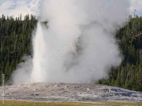 Close up of spurts of scalding water and steam from the Old Faithful geyser during an early morning eruption at Yellowstone National Park, Wyoming.