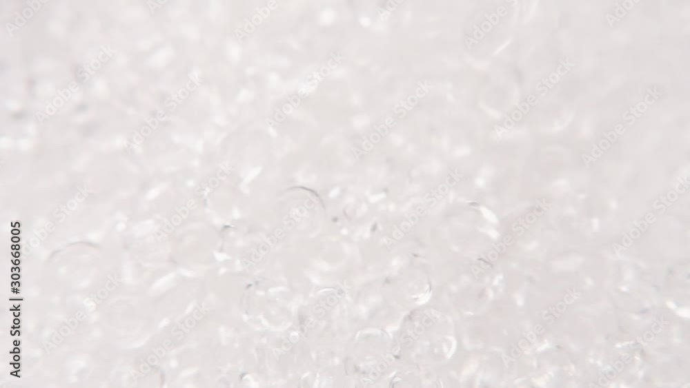 Pouring white clear beads into a white plate. Pouring white clear beads into a white plate.