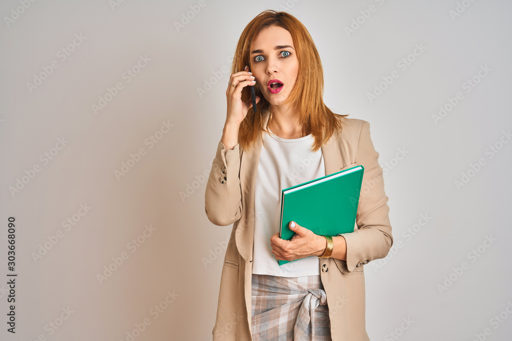 Young caucasian elegant business woman talking on the phone over isolated background scared in shock with a surprise face, afraid and excited with fear expression Young caucasian elegant business woman talking on the phone over isolated background scared in shock with a surprise face, afraid and excited with fear expression