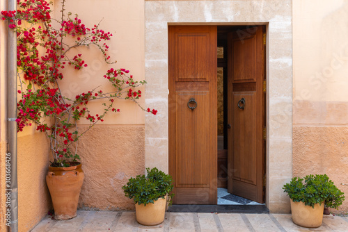 Spanish house with door and flowers on street in beautiful Old Town of Alcudia. Balearic architecture.Majorca island. Spain