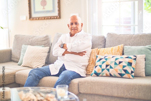 Senior handsome man smiling happy and confident. Sitting on the sofa relaxed at home © Krakenimages.com