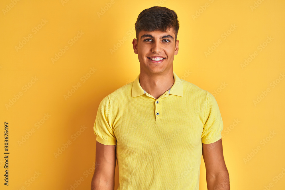 Fototapeta premium Young indian man wearing casual polo standing over isolated yellow background with a happy and cool smile on face. Lucky person.