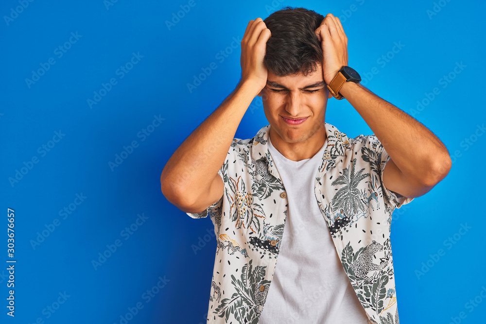 Φωτογραφία Young indian man on vacation wearing hawiaian shirt standing over isolated blue background suffering from headache desperate and stressed because pain and migraine