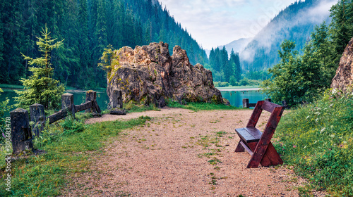 Foggy summer view of Lacu Rosu lake. Picturesque morning scene of Harghita County, Romania, Europe. Beauty of nature concept background. photo