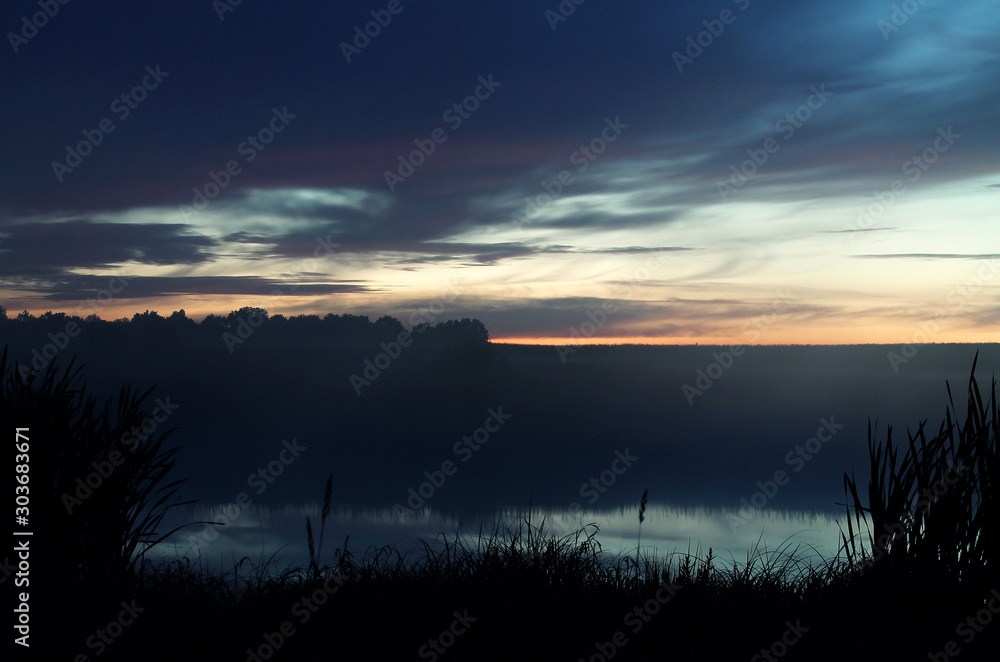 Obraz premium Lake after sunset, grass, backlit