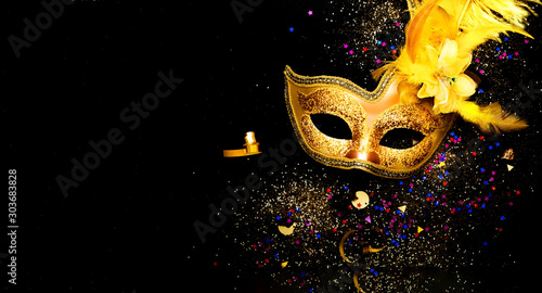 Masquerade mask on black background with sparkles. The concept of traditional holidays. Copy space