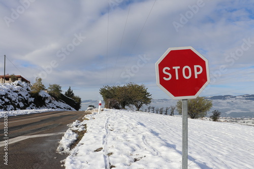 Panneau STOP - panneau de signalisation routière sur fond de paysage enneigé dans le massif du Pilat - Département de la Loire