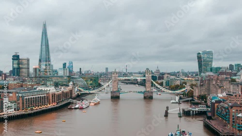 Aerial Drone Hyperlapse Helicopter Cloudy View Of Tower Bridge London City Skyline The Shard Sky Garden And Thames River Time Lapse Clouds Moving photo