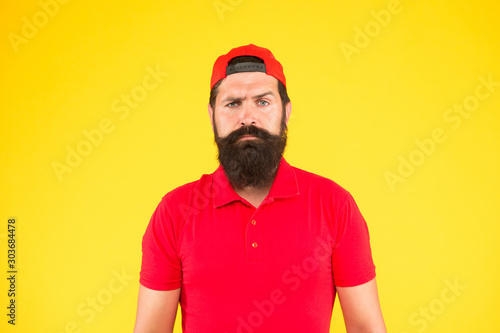 Just fabulous hair. sad mature hipster yellow background. bearded man red shirt and cap. male summer fashion. Barber salon and facial hair care. being trendy and brutal. Beard and mustache grooming