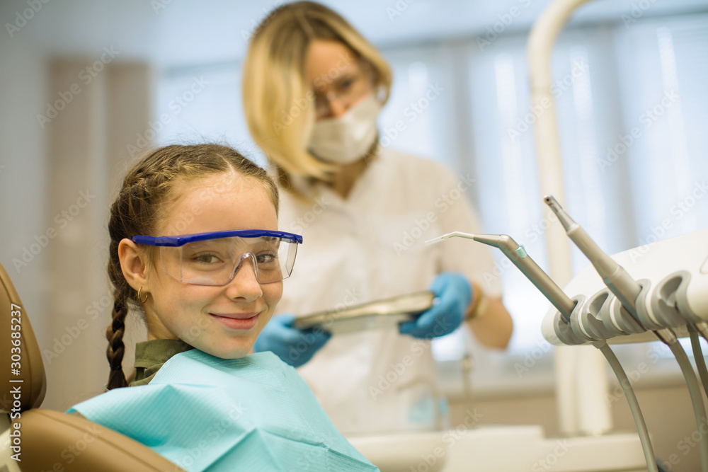 Portrait of little happy girl wearing goggles sitting in a chair in dental office. Portrait of little happy girl wearing goggles sitting in a chair in dental office.