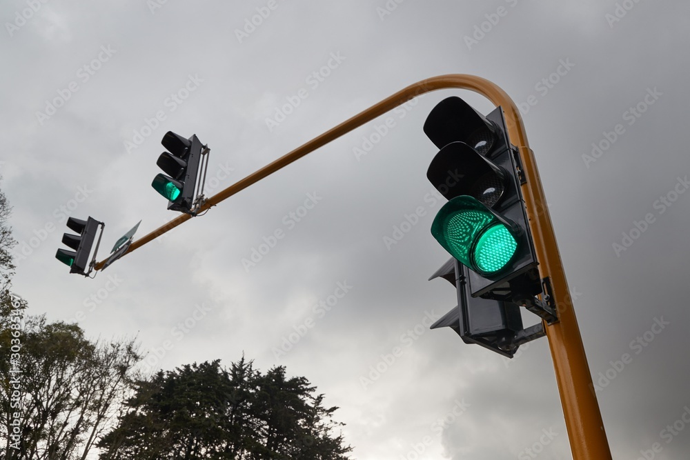 Foto Overhead traffic lights at an intersection, green light
