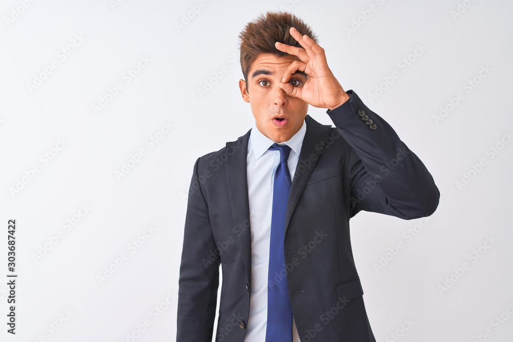 Young handsome businessman wearing suit standing over isolated white background doing ok gesture shocked with surprised face, eye looking through fingers. Unbelieving expression. Young handsome businessman wearing suit standing over isolated white background doing ok gesture shocked with surprised face, eye looking through fingers. Unbelieving expression.