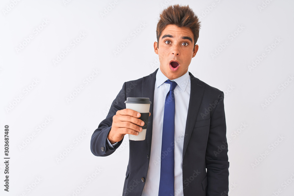 Young handsome businessman wearing suit holding coffee over isolated white background scared in shock with a surprise face, afraid and excited with fear expression Young handsome businessman wearing suit holding coffee over isolated white background scared in shock with a surprise face, afraid and excited with fear expression