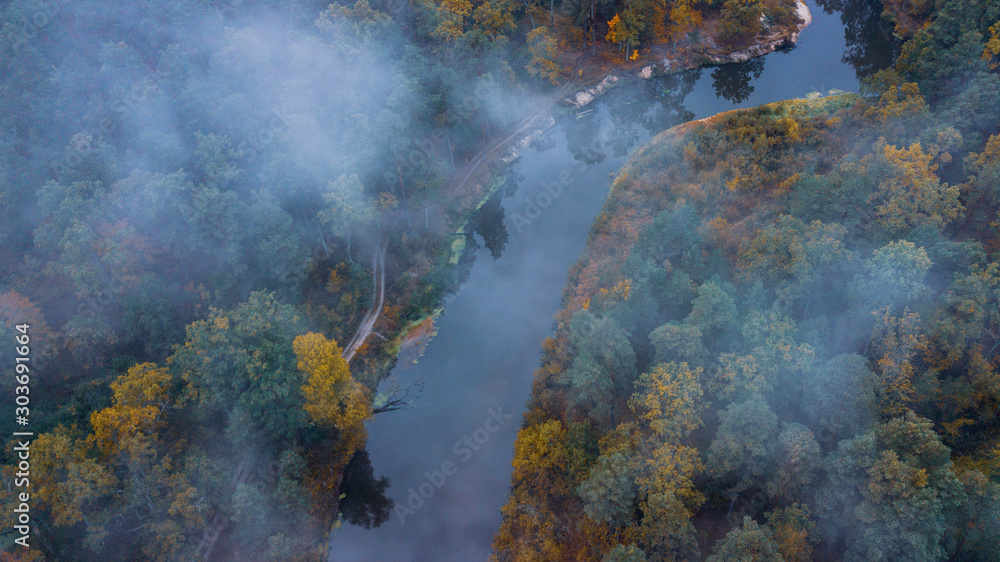 Aerial view of the forest under clouds during the autumn. River Sluch in Belarus.