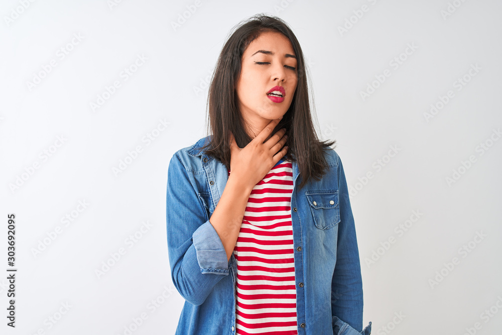 Young chinese woman wearing striped t-shirt and denim shirt over isolated white background Touching painful neck, sore throat for flu, clod and infection Young chinese woman wearing striped t-shirt and denim shirt over isolated white background Touching painful neck, sore throat for flu, clod and infection