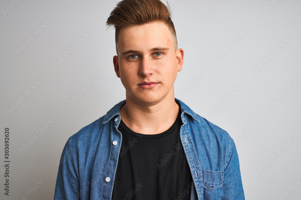 Obraz premium Young handsome man wearing denim shirt standing over isolated white background with a confident expression on smart face thinking serious